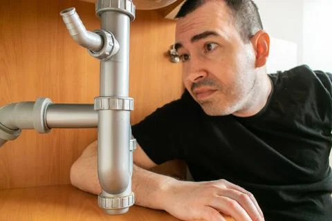 Drain Problems, blockage plumbing kitchen sink pipe unclog plunger man hand h Stock Photos