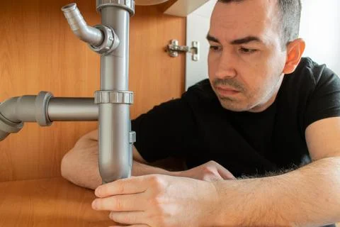 Drain Problems, blockage plumbing kitchen sink pipe unclog plunger man hand h Stock Photos