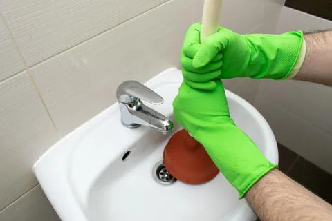 Drain Problems, blockage plumbing sink unclog plunger force cup male man hand Stock Photos