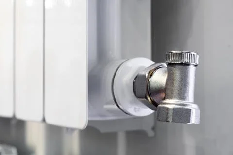 Drain Valve mounted on a white heating battery. Stock Photos