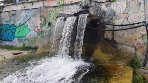 Drainage of clean running water on a graffiti background. Architecture concept Stock Footage 150821985