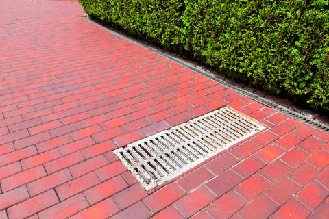 Drainage system with an iron grid infrastructure of a park zone. Stock Photos