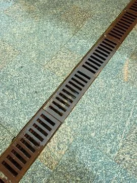Drainage system on a stone pavement surface with water flow observed during.. Stock Photos