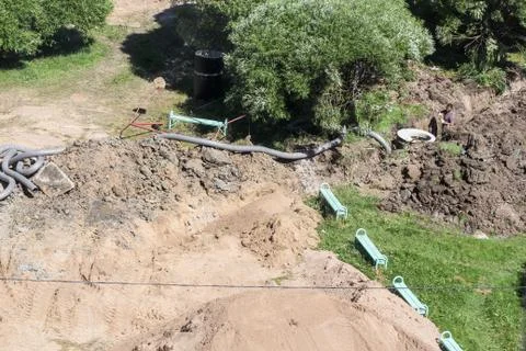 Drainage work in the yard under the trees. 库存照片