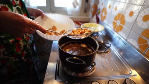 Draining boiling oil from fried struffoli with skimmer Stock Footage 278841215