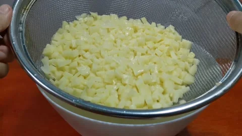 Draining Excess Water of Diced Potatoes Stock Footage 162879917