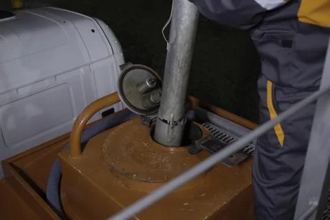 Draining the fluid into the hatch of assessor machine. Stock Photos