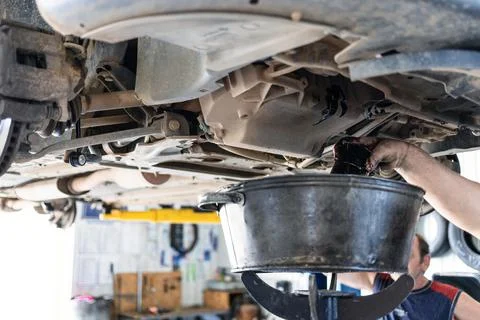 Draining old engine oil from car in car workshop 스톡 사진