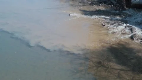 Draining sewage from pipe into river. Waste water industry. Water pollution Stock Footage 270804899