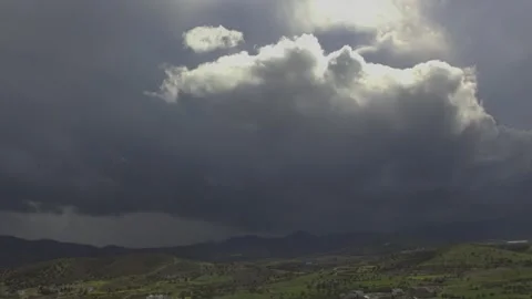 Dramatic 4K Time Lapse of Dark Storm Clouds Over Rolling Hills Stock Footage 323835987