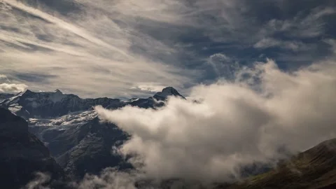 Dramatic 4K Timelapse of Clouds Rolling Over Majestic Mountains Video stock 323835995