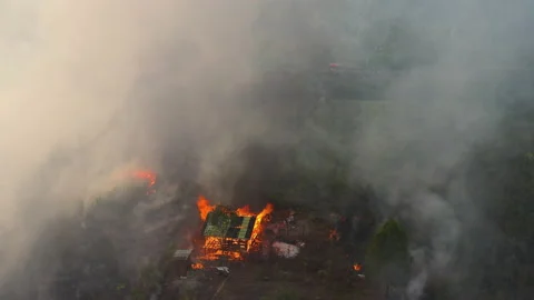 Dramatic Aerial of Burning House Amongst Peat Fire, Indonesia Stock Footage 142510890