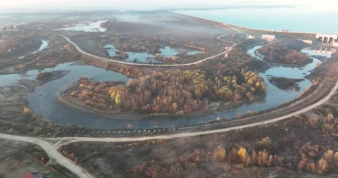 Dramatic aerial drone footage of a small river by the lake. Cinematic rotating Video stock 198356744