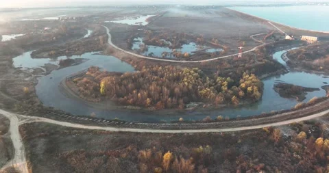 Dramatic aerial drone footage of a small river by the lake. Cinematic rotating Stock Footage 198357966