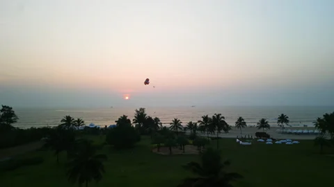 Dramatic Aerial Drone POV Fly Over of Parasail silhouetted against the horizon Stock Footage 238856775