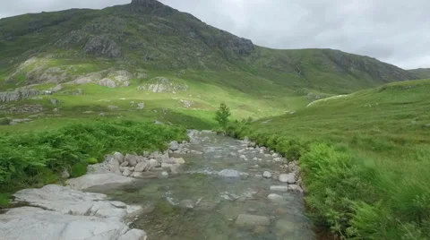 Dramatic aerial / drone shot in Glencoe along a river in the Scottish highlands Stock Footage 58914295