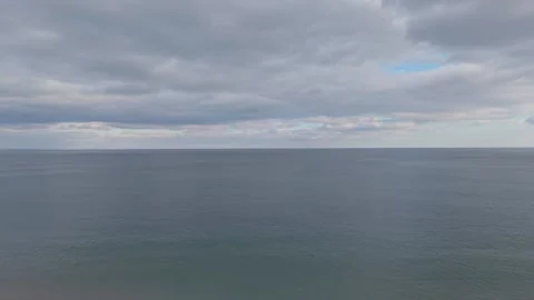 Dramatic aerial drone view of calm sea under heavy clouds Stock Footage 322538124
