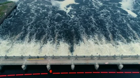 Dramatic aerial flyover shot of a dam in full release mode. Camera tilts down. Stock Footage 136076169