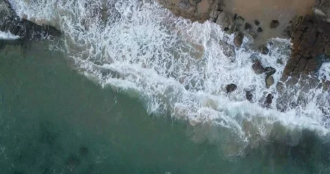Dramatic aerial footage of powerful ocean waves crashing against rocky cliffs Stock Footage 317786060