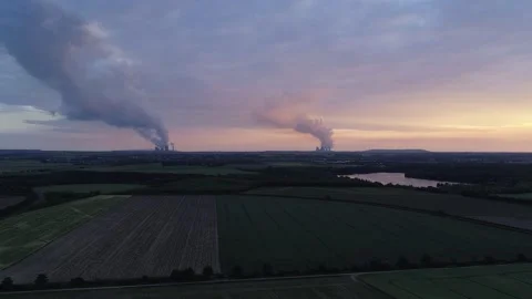 Dramatic aerial green fields lignite power plants giant clouds during sunset Stockbeeldmateriaal 232029730