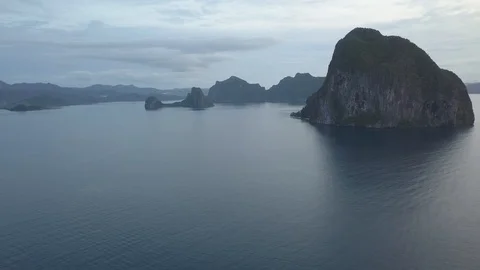 Dramatic aerial over ocean of mountains rising from the sea in Asia - Ungraded Stock Footage 91274703