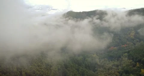 Dramatic Aerial Perspective of Cloud-Covered Highlands Stock Footage 312901533