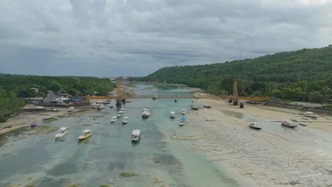 Dramatic aerial perspective flying over the yellow bridge connecting nusa Stock Footage 328995751