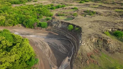 Dramatic aerial perspective revealing the eroded canyons and lush vegetation of Stock Footage 332058192