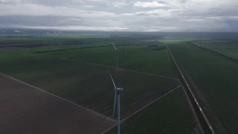Dramatic aerial perspective of a wind farm with towering turbines generating Stock Footage 337888172