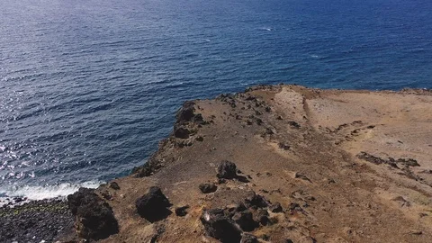 Dramatic aerial pull back and tilt down shot above high rocky cliff, Stock Footage 128944930