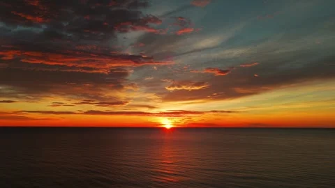 Dramatic Aerial Seascape At Sunset With Orange Clouds And Sunlight Reflections Stock Footage 330920472