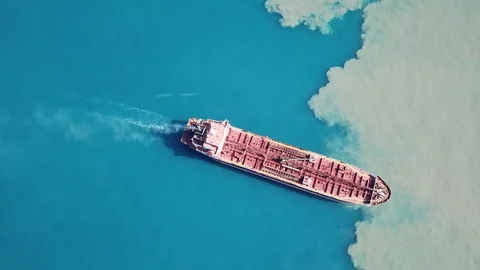 Dramatic Aerial shot of red deck tanker ship sailing on open sea with pollution Stock Footage 110367927