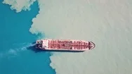 Dramatic Aerial Shot Of Red Deck Tanker Ship Sailing On Open Sea With Pollution Stock Footage
