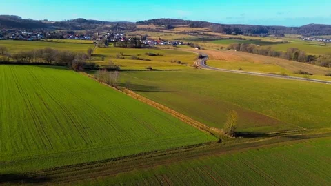 Dramatic Aerial Shot of Winding Road Cutting Through Lush Farmlands Stock Footage 271318709