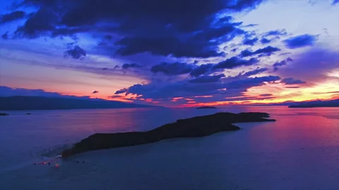 Dramatic aerial sunrise over the ocean and island silhouette Stock Footage 337025991