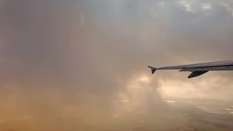 Dramatic aerial view from an airplane window during flight cutting through a Stock Footage 297173280