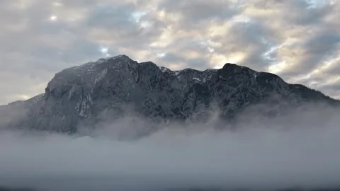 Dramatic aerial view of alpine mountain rising above clouds in Austria Stock Footage 335357548