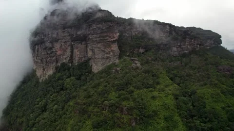 Dramatic aerial view of clouds embracing a majestic mountain peak Stockbeeldmateriaal 332726997