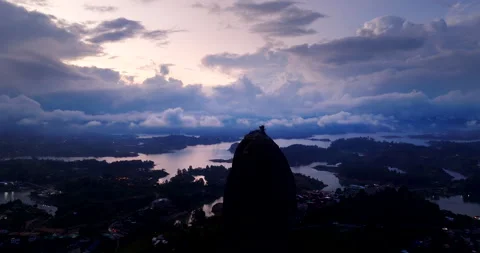Dramatic Aerial View of Giant Monolith Above Reservoir at Moody Sunset Stock Footage 346886827