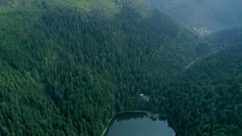 Dramatic aerial view of hidden mountain lake with tiny Stock Footage 327551588