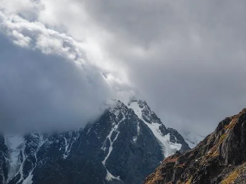 Dramatic aerial view to large snow mountain range under changeable rainy cl.. Stock Photos