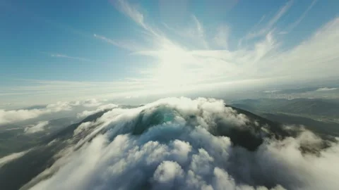 Dramatic Aerial View of Mountain Summit Through Rolling Clouds at Sunrise Stock Footage 319415324