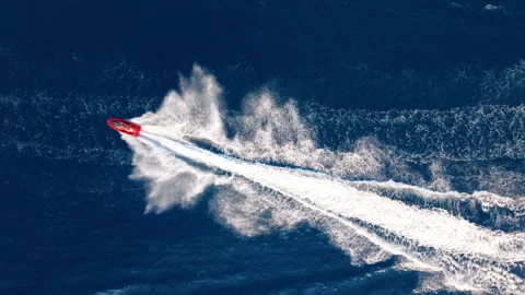 Dramatic Aerial View of Red Speedboat Racing Across the Ocean Stock Footage 330925216