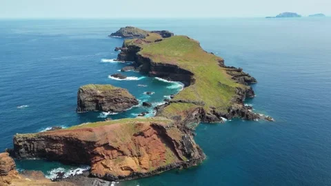Dramatic aerial view of a rugged green island coastline with waves crashing.. Stock Footage 324506240