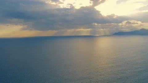 Dramatic aerial view of the sea with rays of light beaming through the clouds Stock Footage 97858390