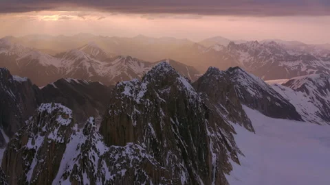 Dramatic aerial view of snowy mountain range at sunset Stock Footage 335107159