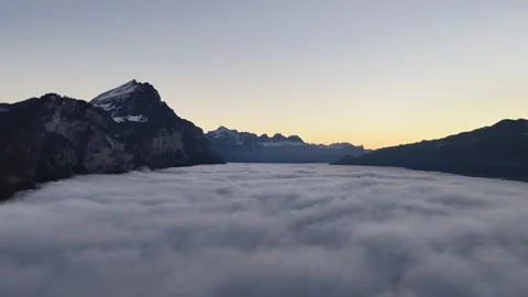 Dramatic aerial view of Swiss peaks floating over a dense sea of fog. The Видео 331686338
