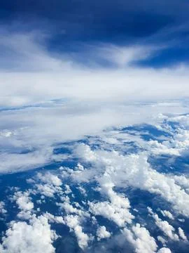 Dramatic aerial view of towering white cumulus clouds beneath sweeping layers of 写真素材