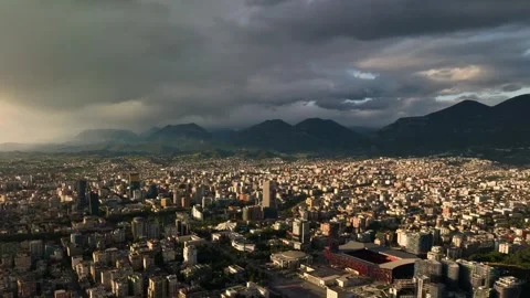 Dramatic Aerial View of Urban Cityscape Under Cloudy Sky in 4K Stock Footage 323836903