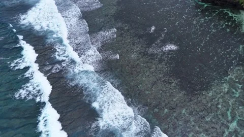 Dramatic aerial view of waves crashing against the rocky coastline of Samoa. Stock Footage 325942423